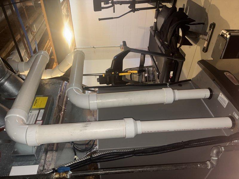 Performed routine MVP heating maintenance service on furnace/air handler system in basement utility area. Inspected all components including blower motor, venting system, and associated PVC exhaust piping. System appears to be functioning properly with no issues identified; installation is well-maintained with secure mounting and proper connections.