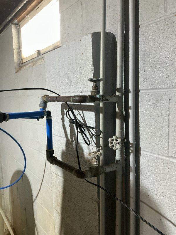 Replaced aging Culligan water softener system (10+ years old) that was actively leaking. Installed new water softener unit with associated plumbing connections, properly integrating it with the existing pressure tank and water treatment system in the basement utility area.