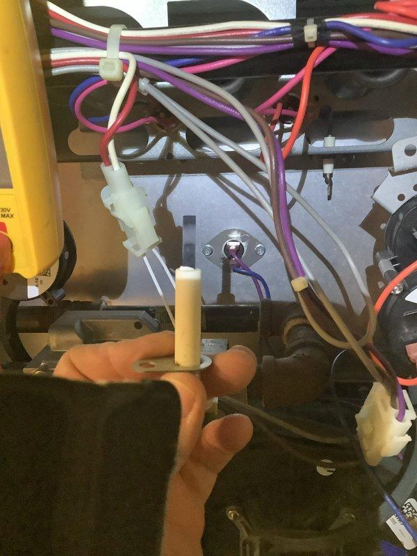 Diagnosed intermittent blower failure on natural gas furnace by inspecting control board and testing electrical components. Multimeter readings revealed low microamp DC current (0.5 μA) at control board connections, indicating faulty flame sensor causing improper fan cycling. Cleaned and replaced flame sensor to restore proper furnace operation before customer's departure.