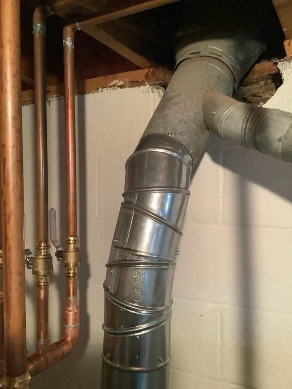 Completed warranty repair on boiler installation that had previously failed inspection due to non-compliant exhaust ducting. Corrected the exhaust duct connection to ensure proper 2" lap at the crimp area, which previously had 1.5" exposure. Verified all copper supply lines, brass valves, and galvanized flue connections were properly secured and functioning according to manufacturer specifications.