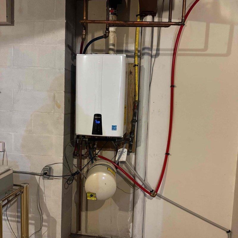 Performed routine maintenance on heating system including pressure testing with digital gauge (readings: 17.1/-17.1). Inspected tankless water heater installation and associated components including expansion tank, copper piping, and gas line connections. Customer renewed maintenance plan; payment collected as agreed.