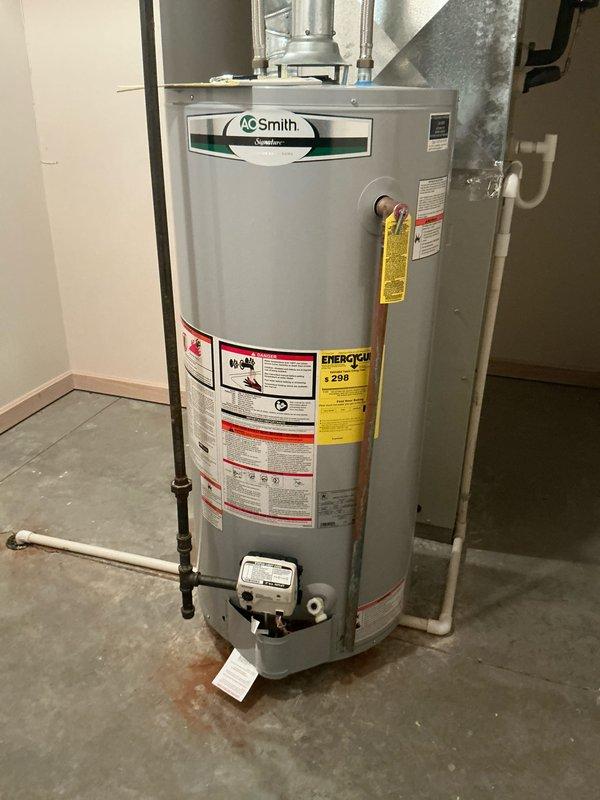 Conducted an HVAC system replacement estimate featuring an RP/II unit with connected galvanized metal ductwork and control valve components. Assessment also included evaluation of existing A.O. Smith Signature water heater showing possible minor leakage indicated by floor discoloration near unit base.