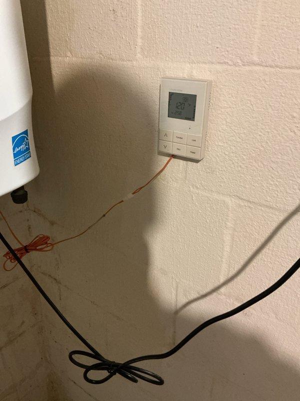 Performed descaling service on tankless water heater to remove mineral buildup and restore optimal performance. Inspected copper and brass pipe infrastructure beneath unit, which showed signs of age and tarnishing. Examined leaking humidifier as requested, noting temperature settings on thermostat (80°) and evaluating connection issues.