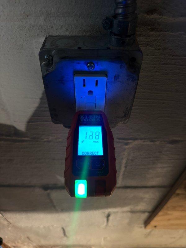 Completed installation of dedicated circuit for tankless PWI. Tested the outlet with digital voltage meter confirming 128 VAC with correct wiring configuration. Verified proper grounding and connection integrity of the new circuit.