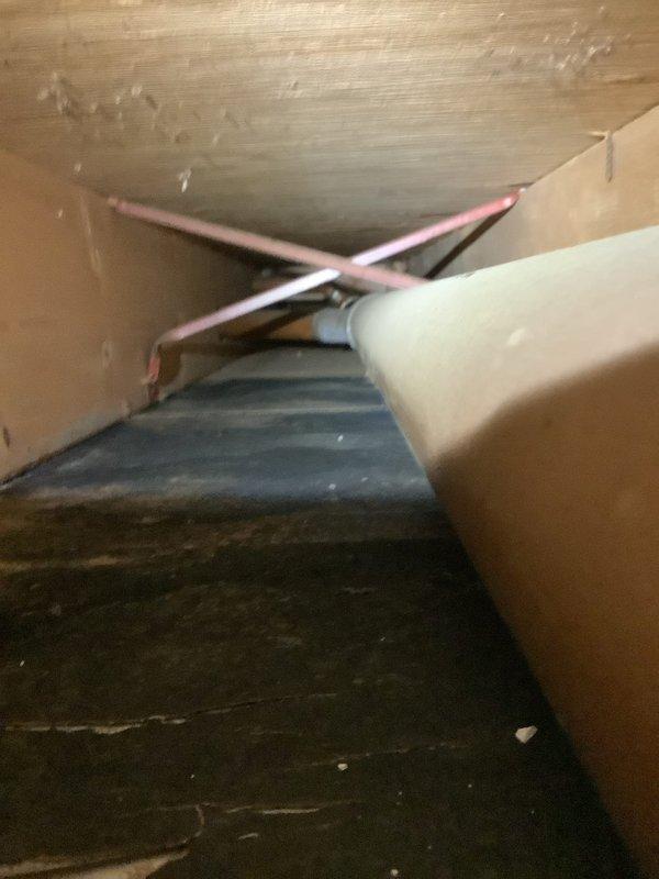 Inspected confined area in basement to locate source of water intrusion for new MVP member. Accessed narrow crawlspace to examine copper pipe configuration and surrounding structural elements. Documented condition of the area with photos for further assessment of the leak source.