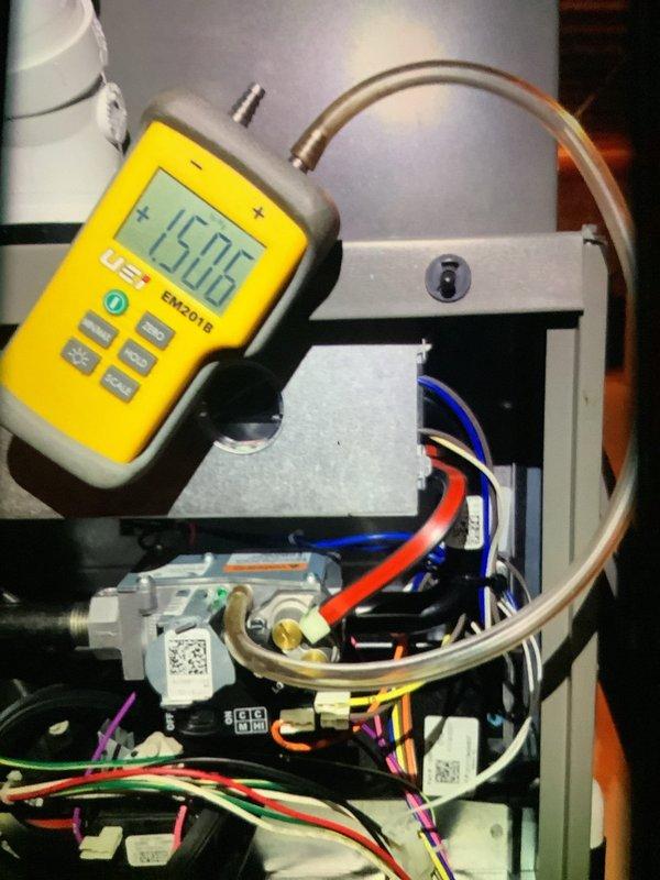 Performed routine maintenance on a 3-year-old heating system. Conducted electrical diagnostics with multimeter showing 15.06 reading on control board components. Inspected furnace unit and ventilation system including PVC exhaust pipes, confirming proper installation and operation.