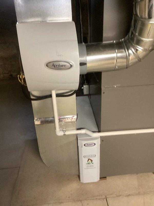 Performed annual preventative maintenance on furnace system with MVP service. Inspected Aprilaire whole-home humidifier installation and connections to ductwork. Examined air filter which showed normal accumulation of dust/debris; documented condition with photos for service record.
