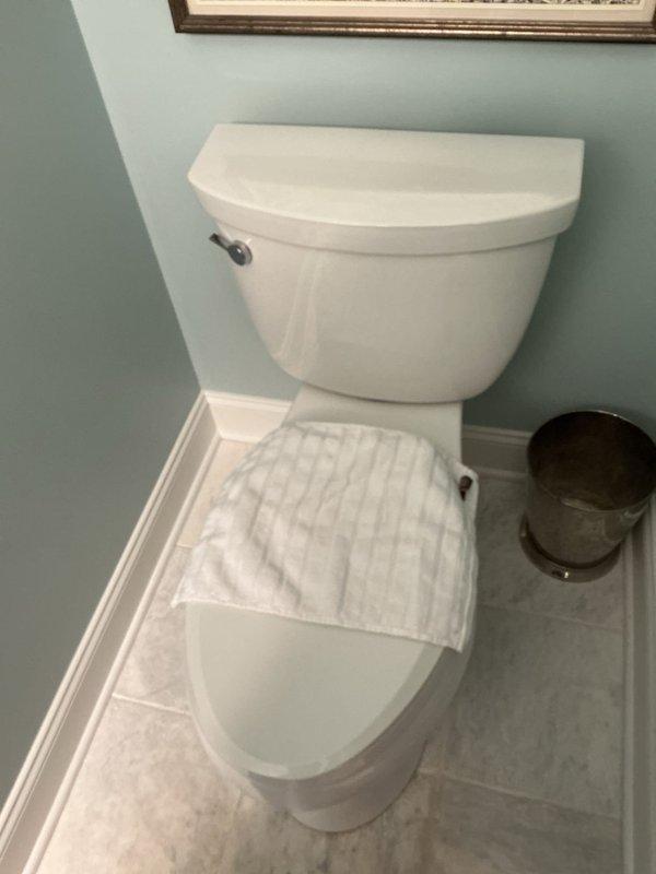 Responded to service call for toilet with broken flapper. Upon inspection, found existing flapper valve showed significant mineral buildup and wear with one side detached and the other loosely connected. Removed old flapper, installed new red rubber flapper valve, and tested flush cycle to confirm proper seal and operation.