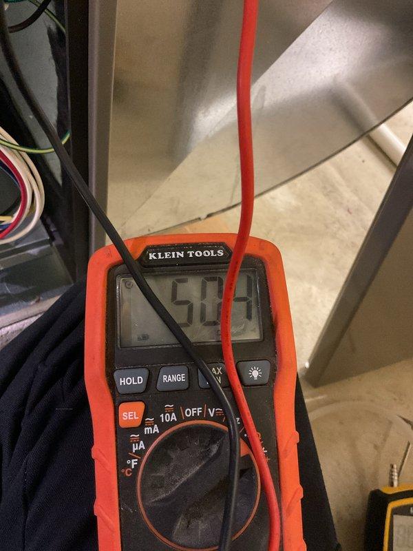 Performed scheduled HVAC heating system tune-up. Conducted electrical testing with multimeter, recording 50.4V at the ECM drive board. Inspected circuit board connections and verified proper operation of electronic components, with all wiring harnesses secure and green indicator light functioning normally.