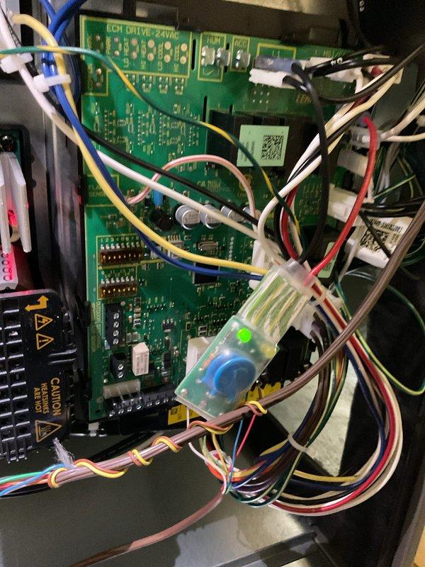 Performed scheduled HVAC heating system tune-up. Conducted electrical testing with multimeter, recording 50.4V at the ECM drive board. Inspected circuit board connections and verified proper operation of electronic components, with all wiring harnesses secure and green indicator light functioning normally.