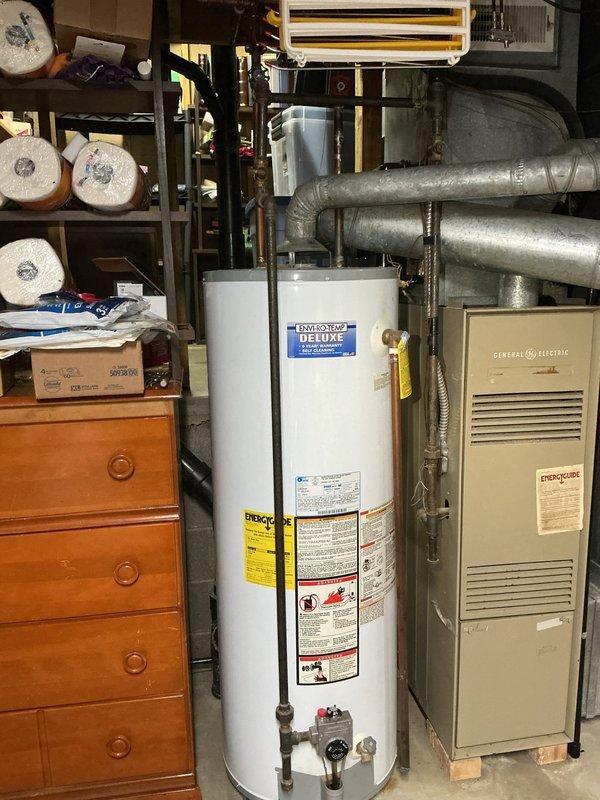 Responded to urgent service call for burst pipes in basement utility area. Inspected exposed plumbing system with significant water damage affecting wooden joists. Assessed damaged hot water tank (PowerStar DELUXE model) and provided separate quotes for pipe repair and complete hot water tank replacement.
