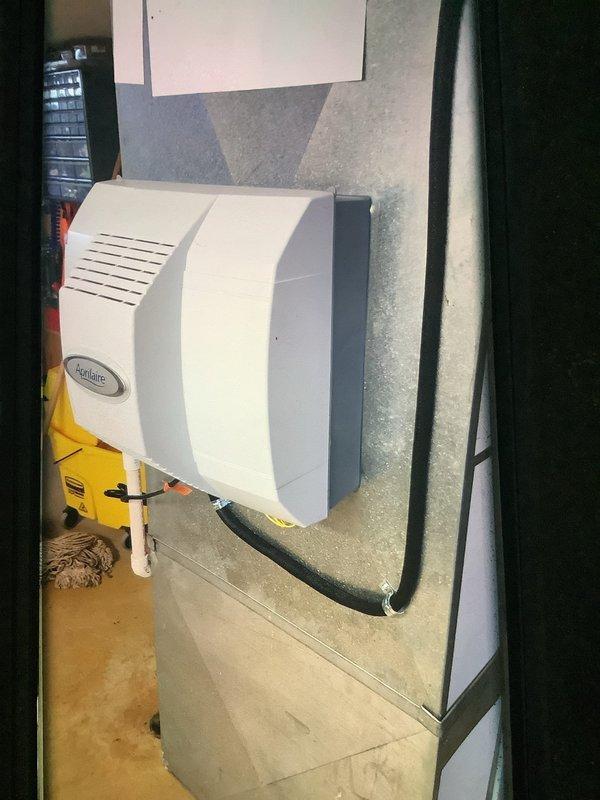 Responded to service call for humidifier maintenance. Inspected Aprilaire humidifier unit mounted on HVAC ductwork and replaced water panel as indicated by system. Also examined air filter which showed significant dust accumulation, indicating replacement was due.
