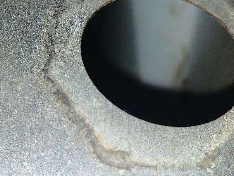 Diagnosed failed heat exchanger on furnace evidenced by significant cracking at combustion chamber and visible rust streaks. Inspection camera revealed extensive fracturing around burner ports, requiring complete system replacement as the unit is unsafe to operate due to potential carbon monoxide hazards.