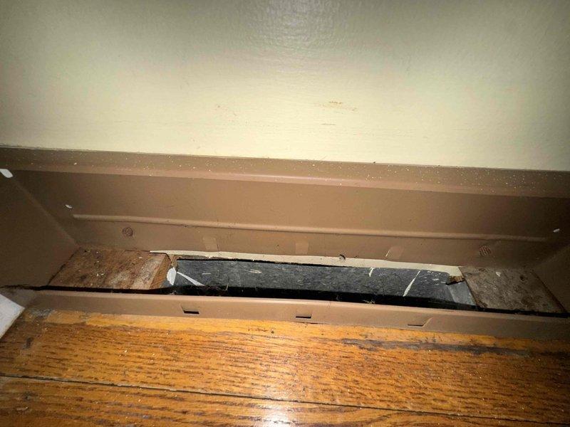 Completed comprehensive duct cleaning service of HVAC system with 14 vents, removing significant dust and debris accumulation as documented in photo evidence. Inspection revealed contamination in baseboard heating unit with visible particulate matter and compromised access panel, which was properly cleaned and secured to restore optimal system functionality and improve indoor air quality.