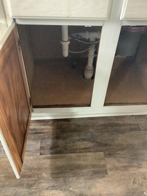 Responded to a water leak service call with water damage affecting multiple areas (bathroom, kitchen, and basement). Inspection revealed water staining around the kitchen sink cabinet and floor, with evidence of leakage from plumbing connections under the sink. Further investigation identified the water heater in the basement as the primary source, showing signs of discharge from the temperature/pressure relief valve with visible water stains on the concrete floor beneath the unit. Documented findings with photos and provided detailed explanation of cause to customer as requested.