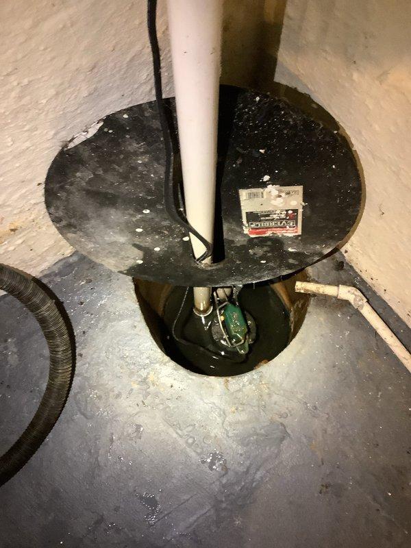 Performed camera inspection of basement drain line to identify source of blockage. Observed sump pump installation with visible water in the pit and examined main floor drain showing significant mineral buildup and water staining around the opening. Documented condition with photos for customer reference.