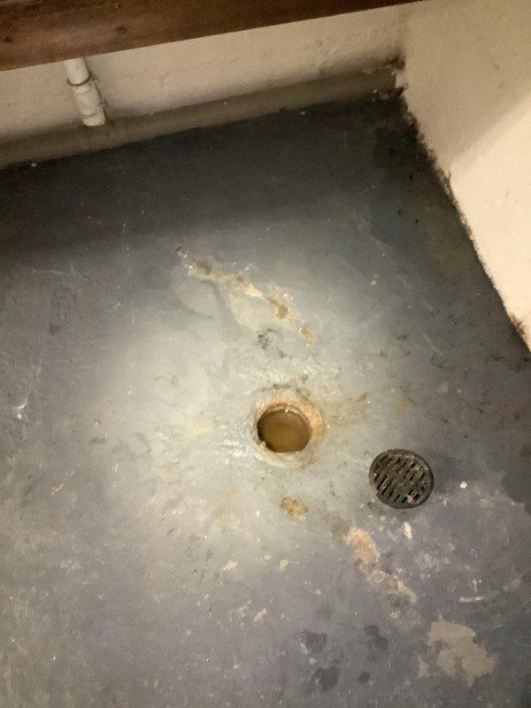 Performed camera inspection of basement drain line to identify source of blockage. Observed sump pump installation with visible water in the pit and examined main floor drain showing significant mineral buildup and water staining around the opening. Documented condition with photos for customer reference.