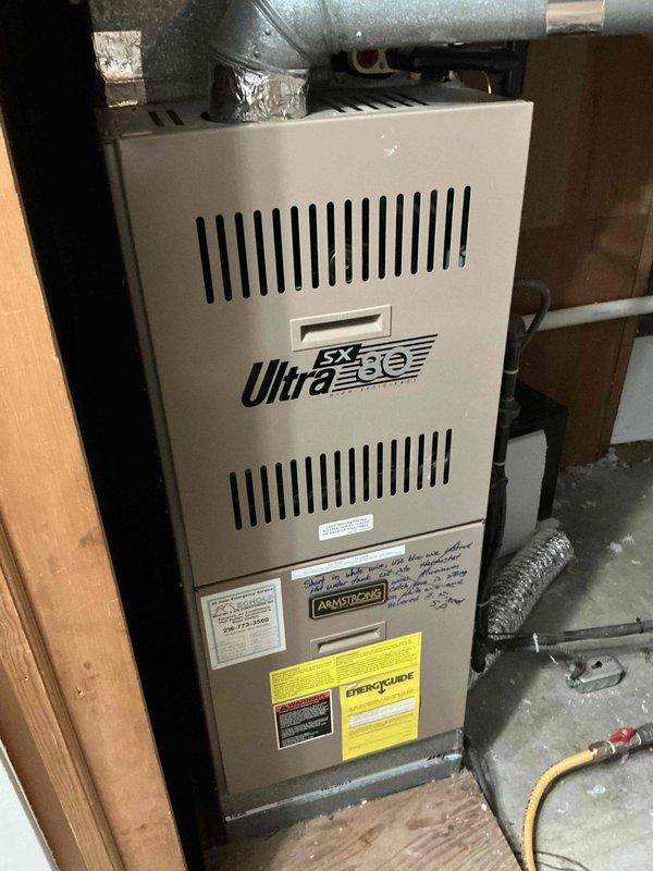 Completed replacement of 32-year-old furnace with new Armstrong Ultra SX model. System was properly installed in utility area with all necessary ductwork connections, including sealed metal elbow joints and flexible ducting. Final inspection confirmed proper installation with all manufacturer safety labels in place and system functioning as designed.