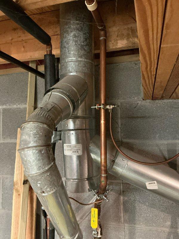 Completed installation of 80% furnace, air conditioning system and hot water tank in utility area. Installation included proper routing of galvanized metal ductwork with appropriate transitions and elbow joints, connection of copper refrigerant lines, and installation of PVC condensate drainage system. All components were professionally mounted and secured to concrete block walls with proper clearances maintained.
