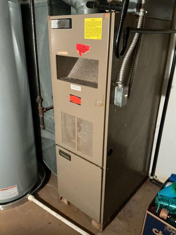 Successfully completed installation of an 80% efficiency furnace unit in utility area. Properly connected unit to existing ductwork and ventilation system, ensuring all safety components and warning labels are in place. Final inspection confirms proper placement adjacent to water heater with appropriate clearances maintained.