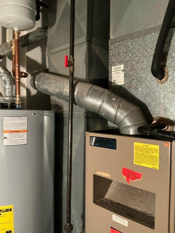 Successfully completed installation of an 80% efficiency furnace unit in utility area. Properly connected unit to existing ductwork and ventilation system, ensuring all safety components and warning labels are in place. Final inspection confirms proper placement adjacent to water heater with appropriate clearances maintained.