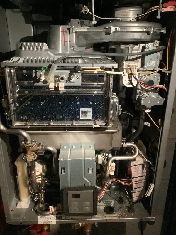 Performed scheduled maintenance on 35-year-old residential tanked water heater, conducting a complete flush to remove sediment buildup. Inspection revealed significant oxidation and corrosion on brass valve connections, particularly evident in the copper components showing greenish-brown patina. System was returned to proper working condition after service.