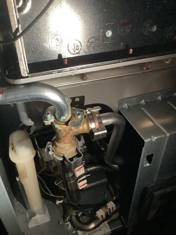 Performed scheduled maintenance on 35-year-old residential tanked water heater, conducting a complete flush to remove sediment buildup. Inspection revealed significant oxidation and corrosion on brass valve connections, particularly evident in the copper components showing greenish-brown patina. System was returned to proper working condition after service.