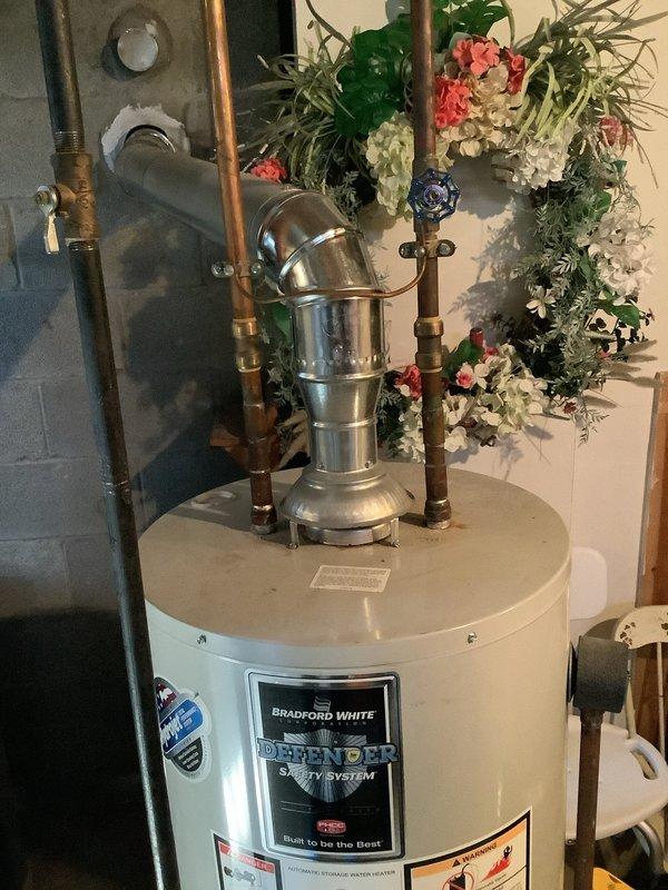 Performed diagnostic inspection of 10-year-old Bradford White Defender water heater located in basement utility area. Evaluated unit condition, connections, and venting system to determine replacement necessity. Customer was provided with detailed replacement options based on assessment findings.