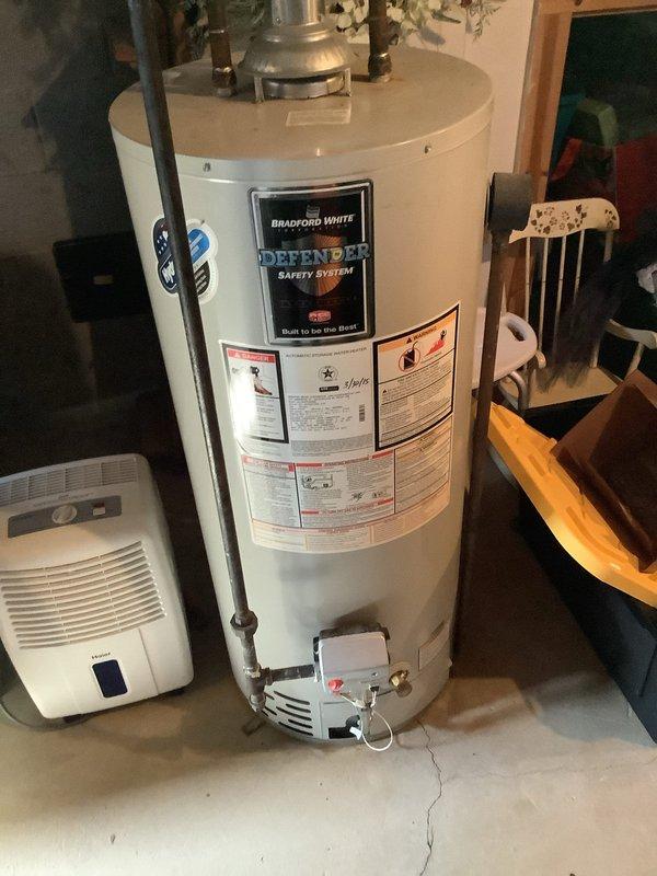 Performed diagnostic inspection of 10-year-old Bradford White Defender water heater located in basement utility area. Evaluated unit condition, connections, and venting system to determine replacement necessity. Customer was provided with detailed replacement options based on assessment findings.
