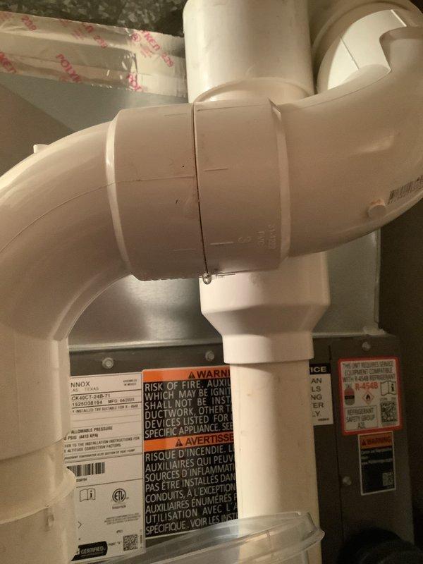 Diagnosed condensate leak from exhaust pipe on furnace. Inspected PVC vent system and identified improper drainage at elbow joint. Repaired connection and verified heat operation was not affected by the leak.