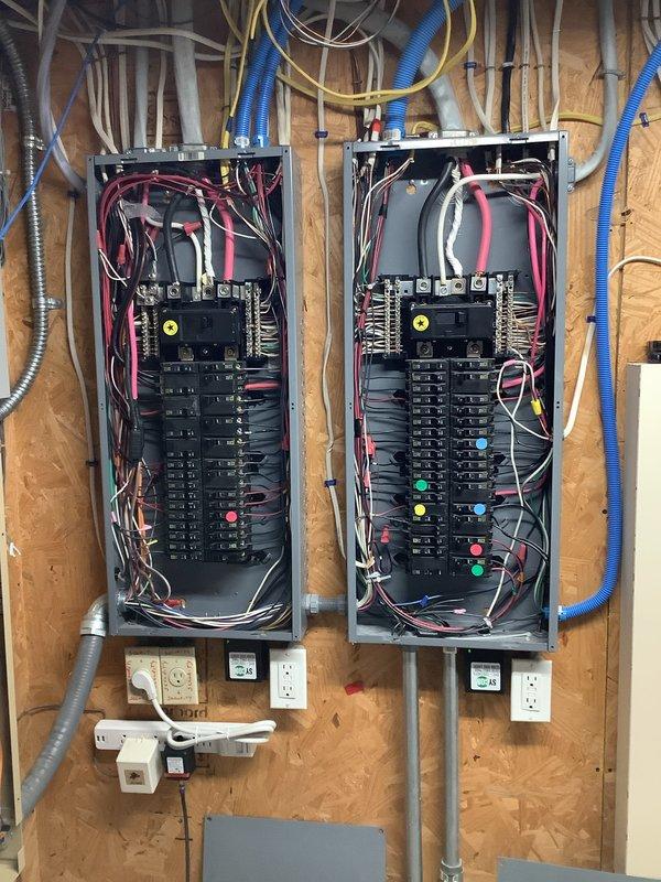 Inspected dual electrical breaker panel installation with exposed interior components to assess generator removal requirements. Documented existing circuit configurations and wiring connections through detailed photos, noting weathered outdoor junction box with exposed terminal connections that would require proper disconnection during generator removal process.