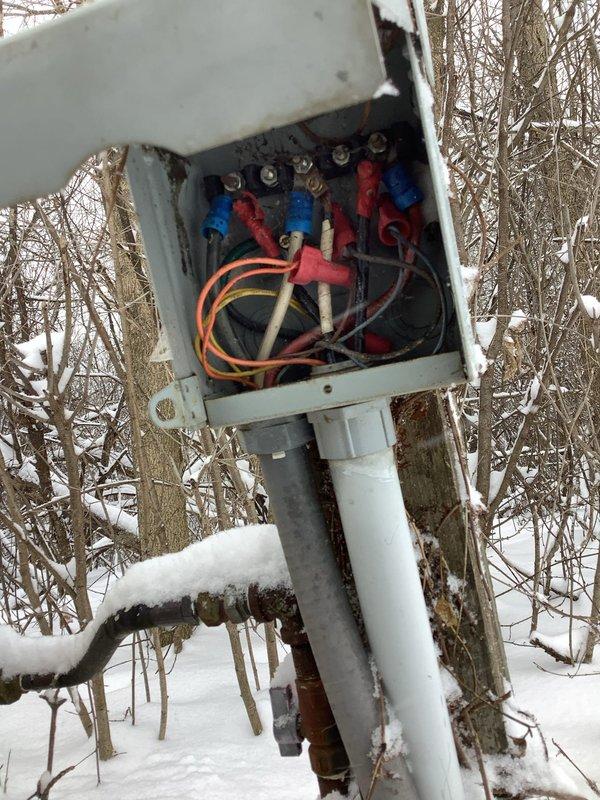 Inspected dual electrical breaker panel installation with exposed interior components to assess generator removal requirements. Documented existing circuit configurations and wiring connections through detailed photos, noting weathered outdoor junction box with exposed terminal connections that would require proper disconnection during generator removal process.