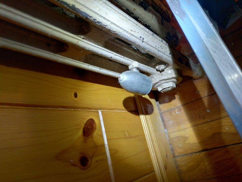 Conducted inspection of tanked water heater system due to high readings indicating potential leak. Examined copper supply lines and connections in utility area. Documented condition of aging radiator pipe with valve fitting and surrounding plumbing infrastructure for further assessment.