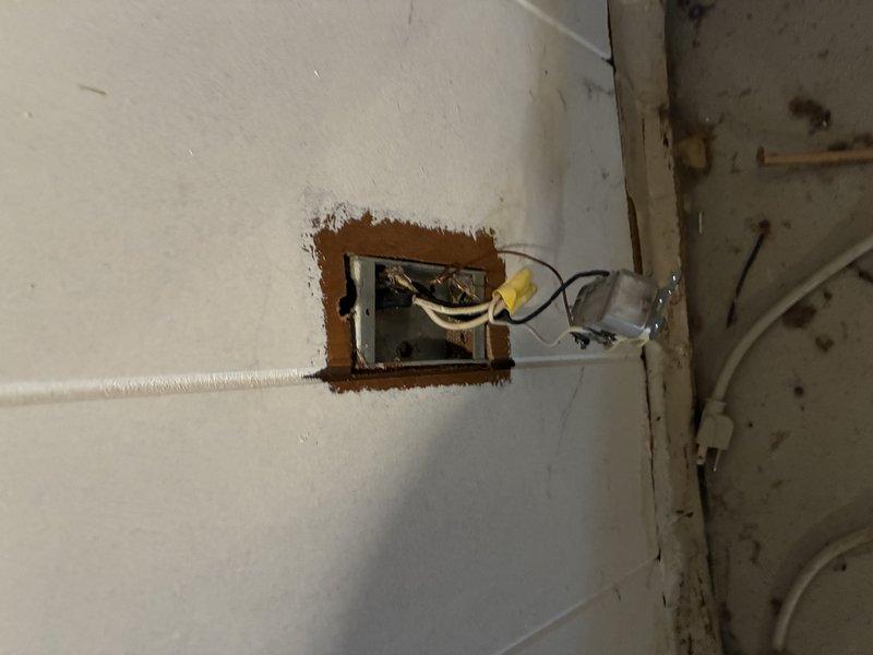 Responded to service call for electrical issue where plumbing snake caused sparking in drain. Inspection revealed improper electrical grounding at exterior junction box with exposed wiring running along metal siding. Repaired faulty ground connection and properly secured exposed junction box in wall to eliminate shock hazard.