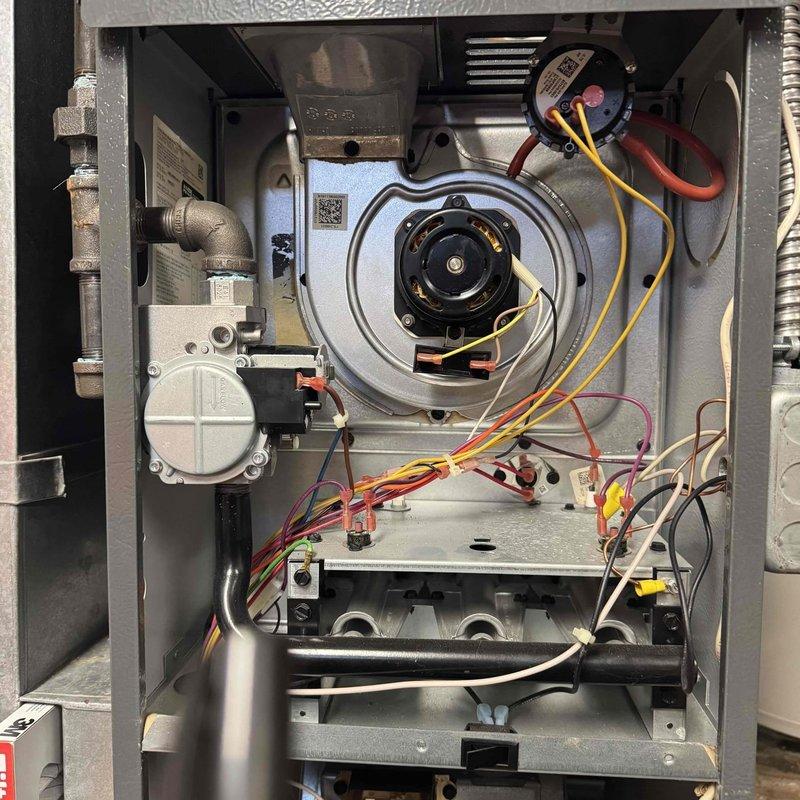 Performed comprehensive tune-up maintenance on 30-year-old Goodman furnace located in basement utility room. Inspected blower motor assembly, electrical connections, and gas valve assembly for proper operation. System shows significant age but is functioning within acceptable parameters after service.