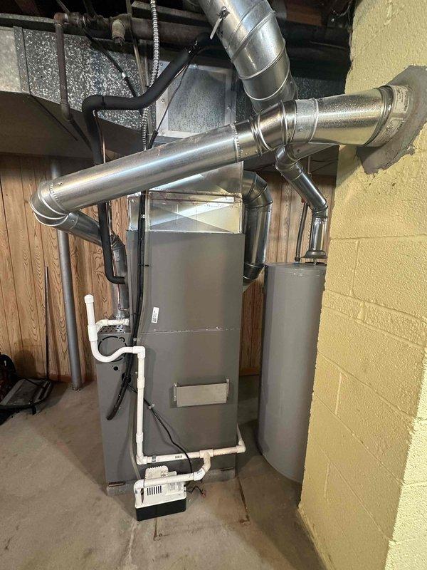 Completed installation of 80% furnace and air conditioning system with proper ductwork connections and PVC condensate drainage. Installed and tested Kidde carbon monoxide alarm as part of safety protocol. System was mounted securely against basement wall with all connections verified for proper operation.