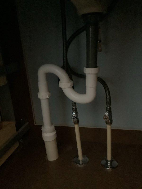Successfully installed new three-piece chrome faucet assembly in bathroom with undermount white oval basin. Inspected and serviced noisy drain, ensuring proper function of the chrome push-button drain stopper. Verified all connections at the PVC P-trap and supply lines for leaks, confirming complete resolution of drainage noise issue.