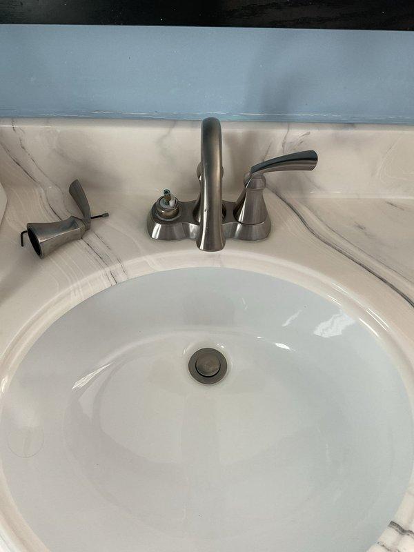 Responded to service call for dual plumbing issues: leaking toilet at base and loose faucet handle in secondary bathroom. Diagnosed toilet seal failure causing water seepage onto floor tiles. Repaired bathroom sink faucet by tightening loose handle assembly and checking for proper operation. Both fixtures were restored to proper working condition with no further leaks observed.