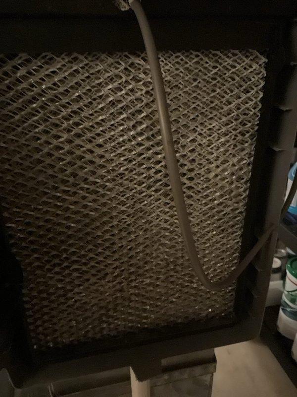 Performed furnace maintenance tune-up on 10-year-old system and diagnosed malfunctioning humidifier. Found evaporative pad severely clogged, restricting water flow through distribution tube, which was causing frequent filter clogging issues. Replaced humidifier pad and restored proper water distribution function.