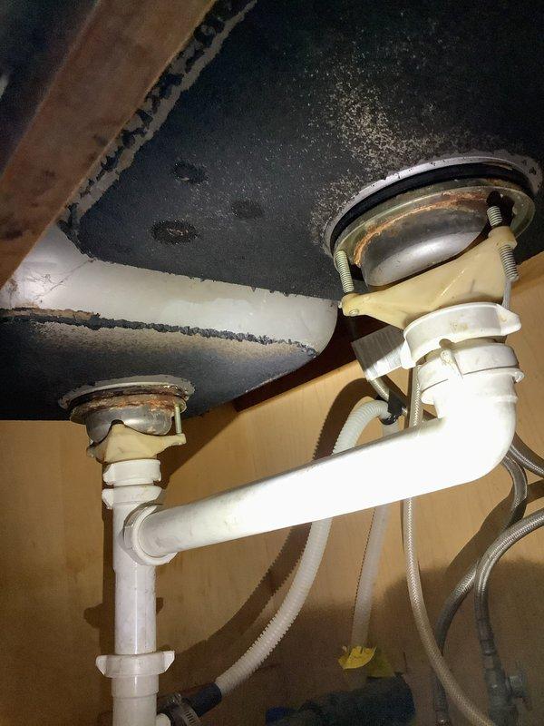 Responded to service call for kitchen drain blockage. Disassembled and cleaned P-trap assembly and garbage disposal drain pipe that was clogged with noodles. System now draining properly with all connections verified secure.