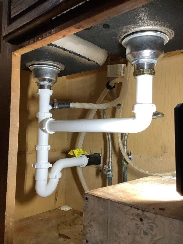 Responded to service call for kitchen drain blockage. Disassembled and cleaned P-trap assembly and garbage disposal drain pipe that was clogged with noodles. System now draining properly with all connections verified secure.