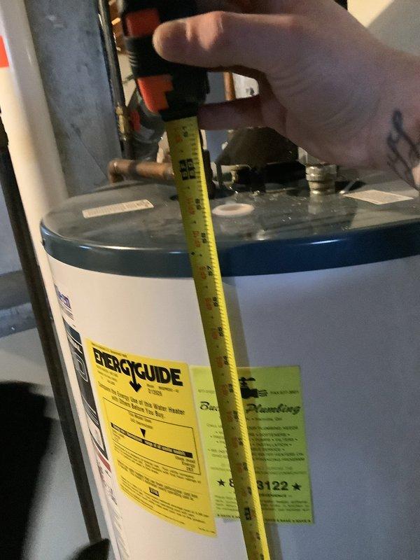 Inspected 20+ year old water heater that was leaking from bottom with rust-colored water. Measured unit and evaluated existing plumbing connections, including copper supply lines and gas valve. Provided replacement quote for the aging unit which has reached end of service life.