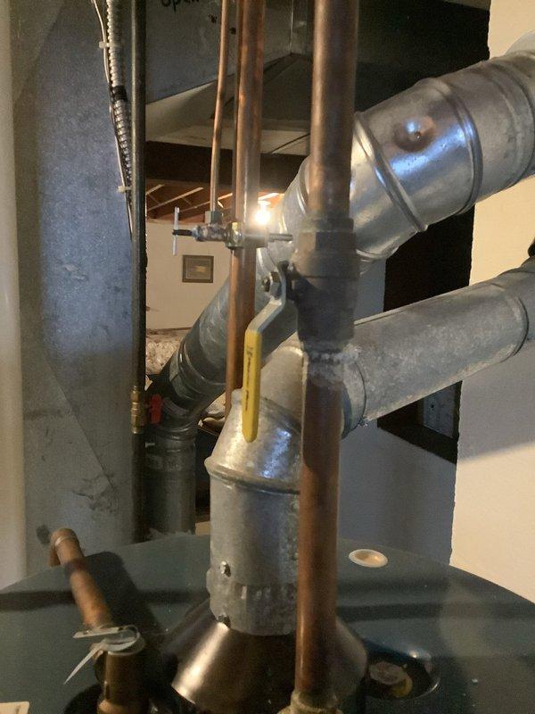 Inspected 20+ year old water heater that was leaking from bottom with rust-colored water. Measured unit and evaluated existing plumbing connections, including copper supply lines and gas valve. Provided replacement quote for the aging unit which has reached end of service life.