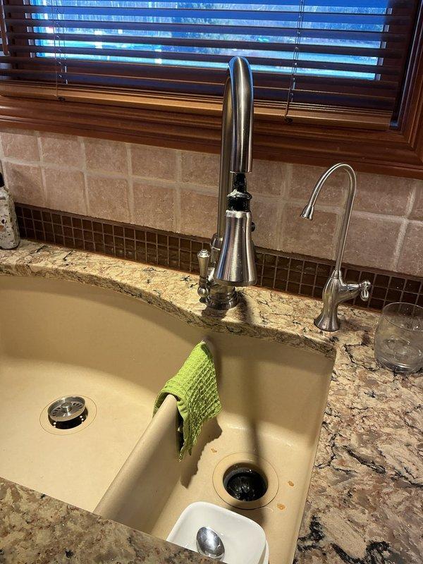 Successfully installed customer-supplied kitchen faucet, replacing existing unit with new modern stainless steel model featuring pull-down sprayer functionality. Properly connected all supply lines and verified operation of both main faucet and secondary filtered water dispenser, ensuring no leaks at connection points.
