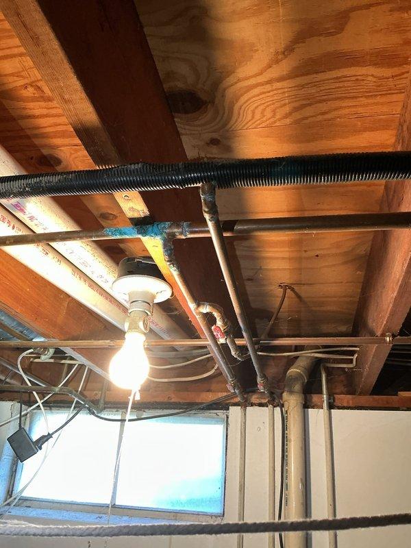 Responded to service call for water leak in basement. Performed diagnostic inspection of the exposed copper pipe system running along wooden joists and identified source of leak. Repaired compromised pipe section and tested system to ensure proper function with no further leakage.