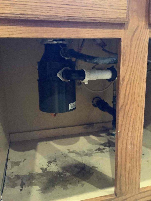 Responded to service call for clogged kitchen sink and leaking faucet. Inspection revealed significant water damage to cabinet flooring beneath sink area, likely from ongoing leak at garbage disposal connection or faucet assembly. Replaced faulty kitchen faucet and cleared drain blockage, restoring proper drainage and eliminating leak.