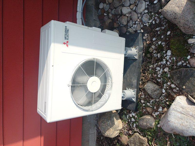 Performed routine maintenance on a 2-year-old Mitsubishi Electric heat pump system. Inspected outdoor condenser unit which was properly installed on stone base with good clearance. Examined internal control board and electrical connections - all components in normal working condition with no signs of wear or damage. System functioning within expected parameters after service.