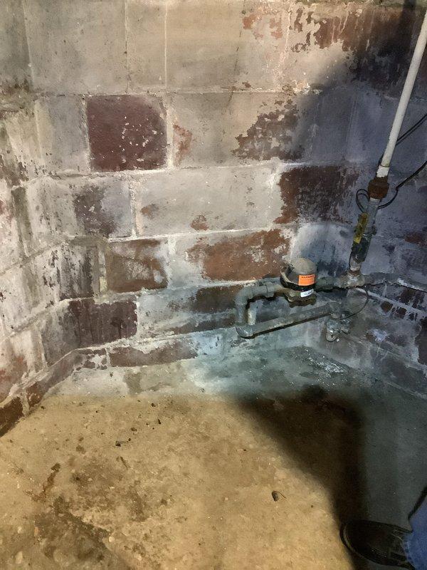 Conducted site assessment for panel upgrade quote at customer's residence. Existing service panel appears to be an older model with standard circuit breaker configuration mounted on a wall in utility area. Noted moisture issues in basement/utility room with visible water damage on concrete block walls, which will need consideration during upgrade planning.
