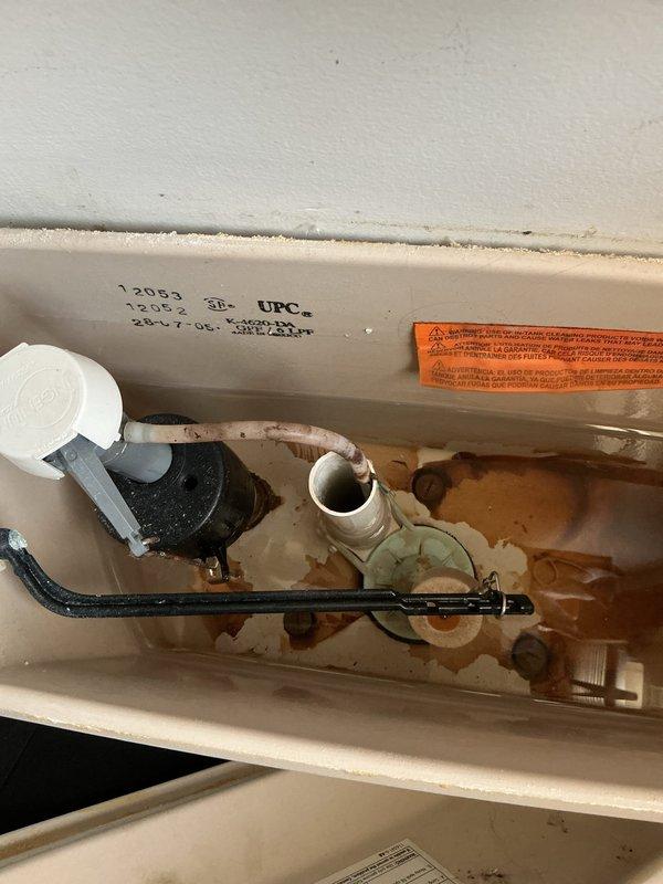 Responded to service call for multiple plumbing issues in a 69-year-old home. Diagnosed and repaired a malfunctioning toilet flush valve causing double flushing, with significant rust and mineral deposits visible in tank. Also addressed kitchen sink problems including leaking faucet, slow drainage, and garbage disposal backup; restored proper function to all affected fixtures.