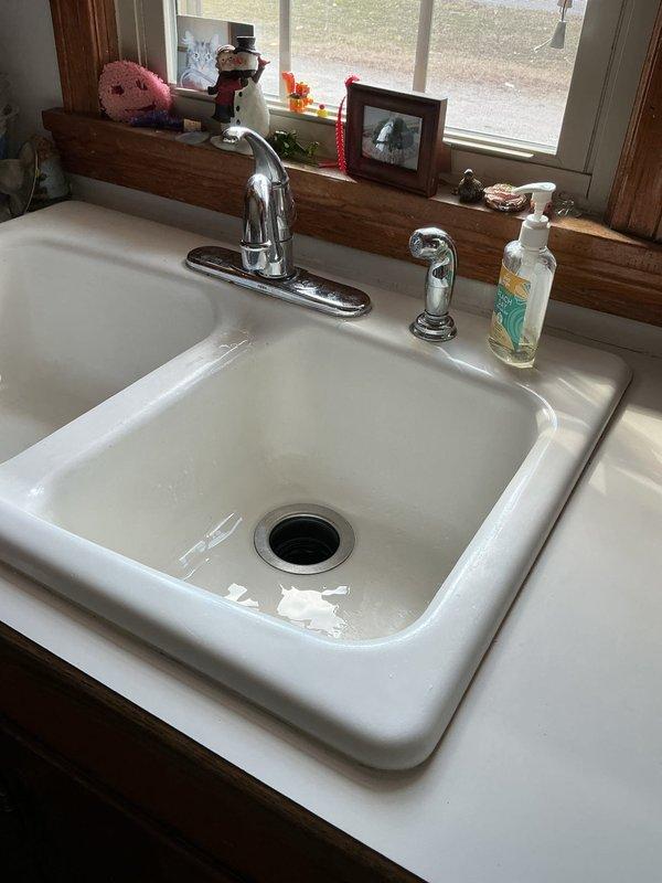 Responded to service call for multiple plumbing issues in a 69-year-old home. Diagnosed and repaired a malfunctioning toilet flush valve causing double flushing, with significant rust and mineral deposits visible in tank. Also addressed kitchen sink problems including leaking faucet, slow drainage, and garbage disposal backup; restored proper function to all affected fixtures.